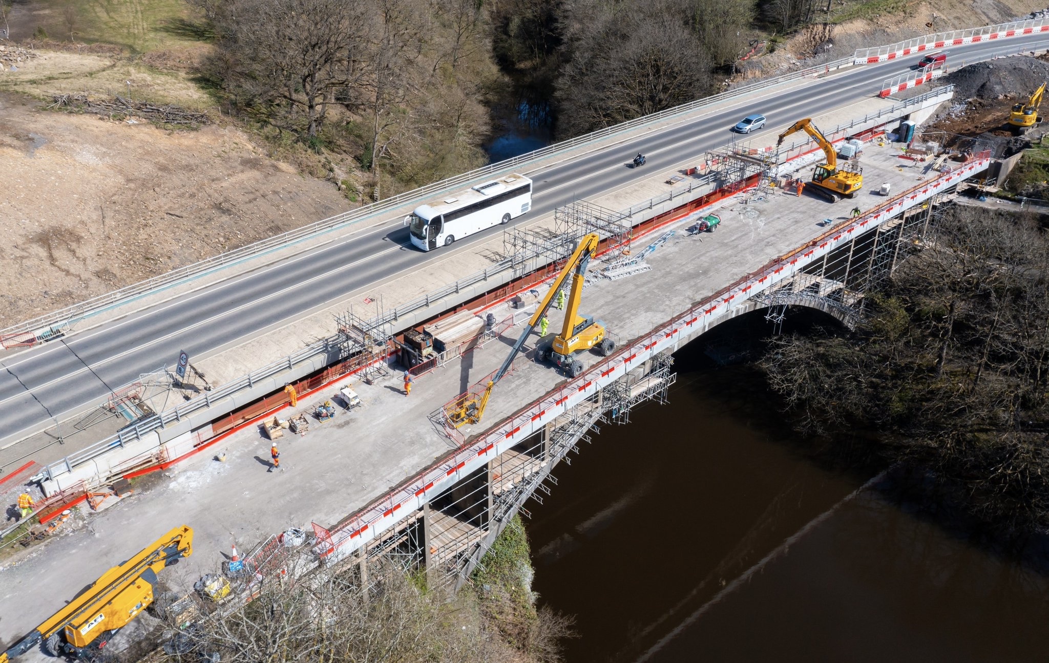 Aerial view of a road bridge over a river gorge under repair, with scaffold and edge protection along both parapets